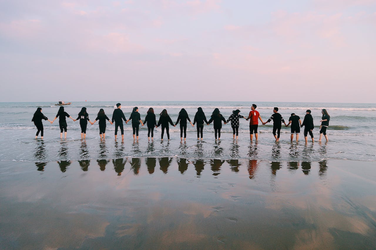 Team Holding Their Hands On Seashore